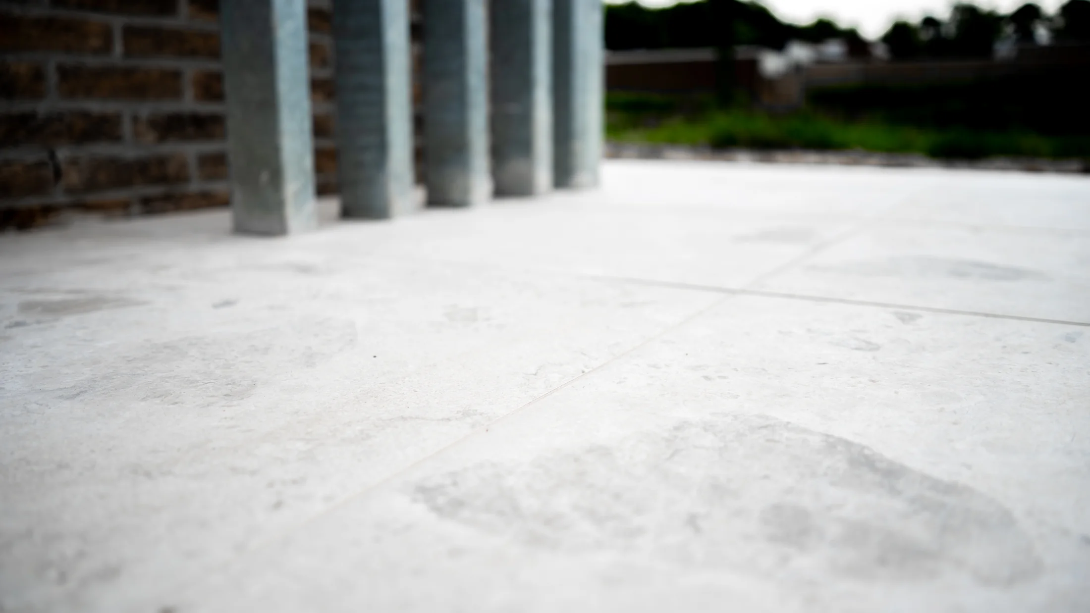 Licht natuursteenlook terras bij een bakstenen woning